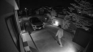 夜間の駐車場を監視する屋外防犯カメラ映像と人物の動き