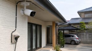 住宅外壁に設置されたコンセント式防犯カメラと屋外配線の様子