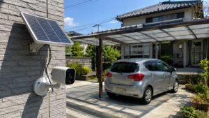 駐車場を見守るソーラー式の屋外防犯カメラとソーラーパネルの設置例