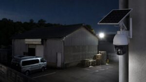 夜間の駐車場や倉庫を見守る屋外ソーラー防犯カメラと照明の様子
