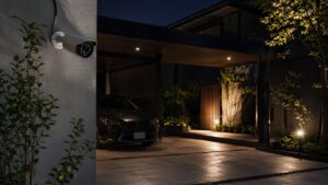 夜間の駐車場を監視する有線屋外防犯カメラと住宅の外観